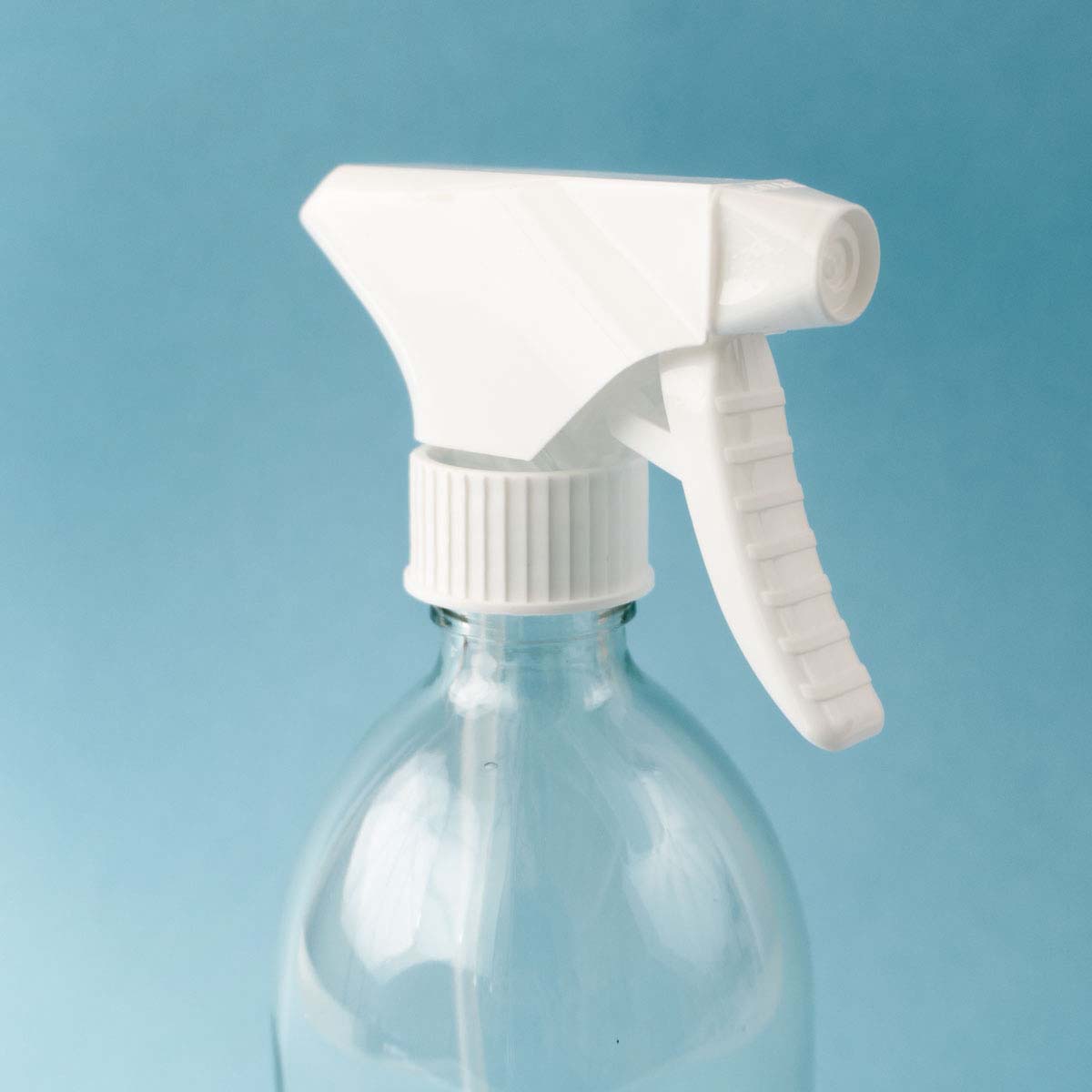 leere Glasflasche mit Sprühaufsatz für selbstgemachte Reiniger